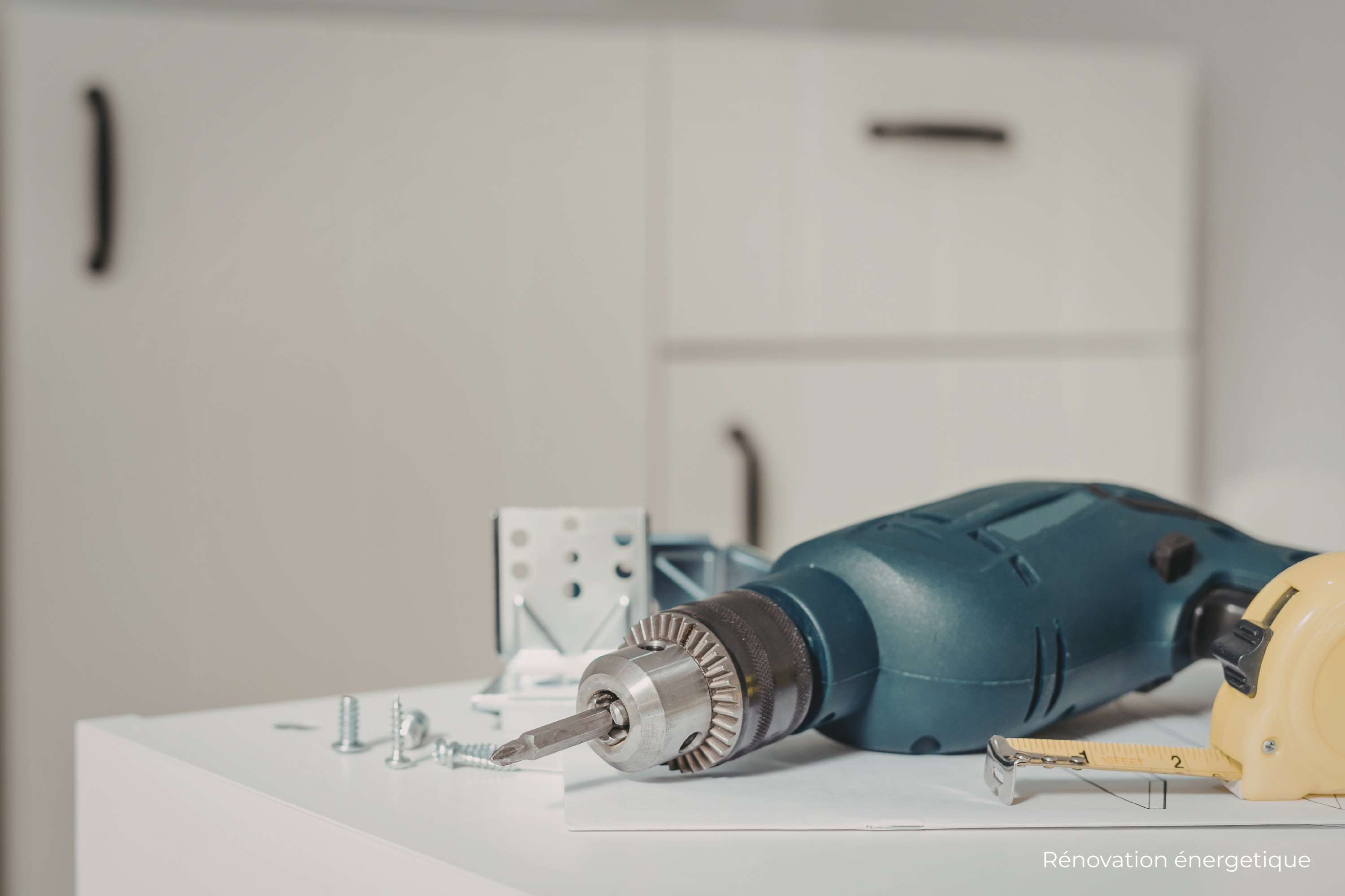 Perceuse avec des vis et un mètre sur une table