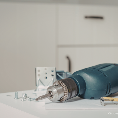 Perceuse avec des vis et un mètre sur une table